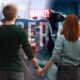 peter parker and mary jane holding hands in front of pictures of marvel s spider man 1