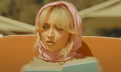 sabrina carpenter wearing head scarf reading book on beach lounger in espresso music video